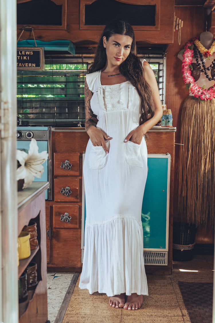 Soul Sister since 1969 long white dress on beautiful woman with a fringe shawl and retro floppy hat standing in a vintage trailer