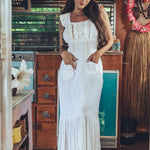 Soul Sister since 1969 long white dress on beautiful woman with a fringe shawl and retro floppy hat standing in a vintage trailer