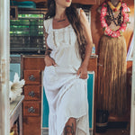 Soul Sister since 1969 long white dress on beautiful woman with a fringe shawl and retro floppy hat standing in a vintage trailer