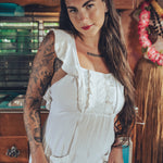Soul Sister since 1969 long white dress on beautiful woman with a fringe shawl and retro floppy hat standing in a vintage trailer