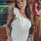 Soul Sister since 1969 long white dress on beautiful woman with a fringe shawl and retro floppy hat standing in a vintage trailer