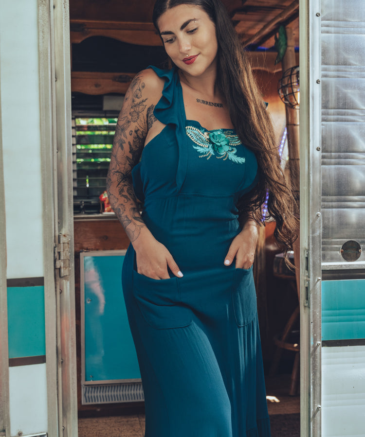 beautiful bohemian embroidered blue dress on woman in a retro trailer