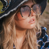 Woman wearing a black witch hat and sunglasses with a blurred natural background wearing Soul Sister since 1969.