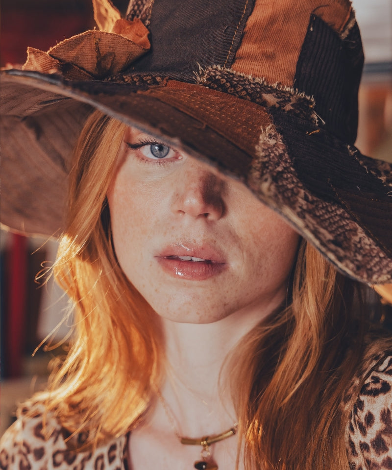 Person wearing a large, decorative hat with a leopard print pattern.