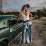Woman in a vintage outfit standing next to a green car with a motorcycle in the background wearing Soul Sister since 1969.