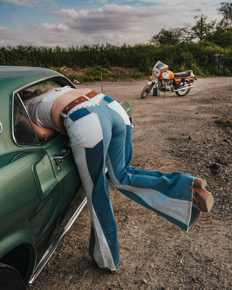 Person leaning out of a car window with a motorcycle in the background wearing Soul Sister since 1969.