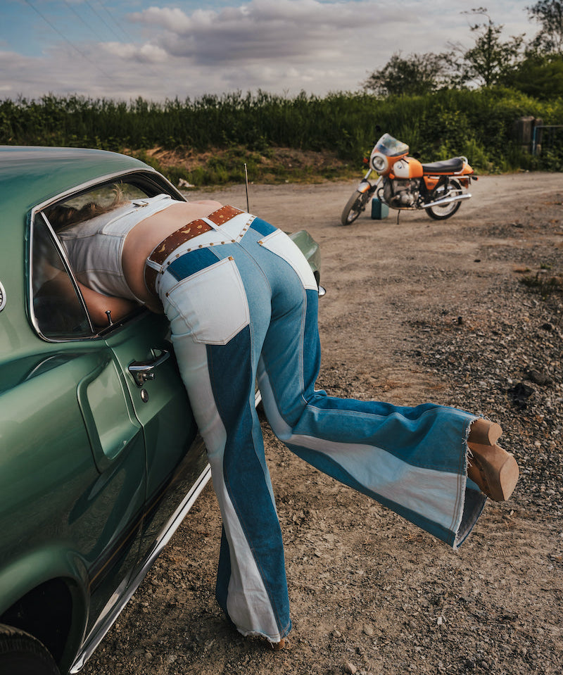 Person leaning out of a car window with a motorcycle in the background wearing Soul Sister since 1969.