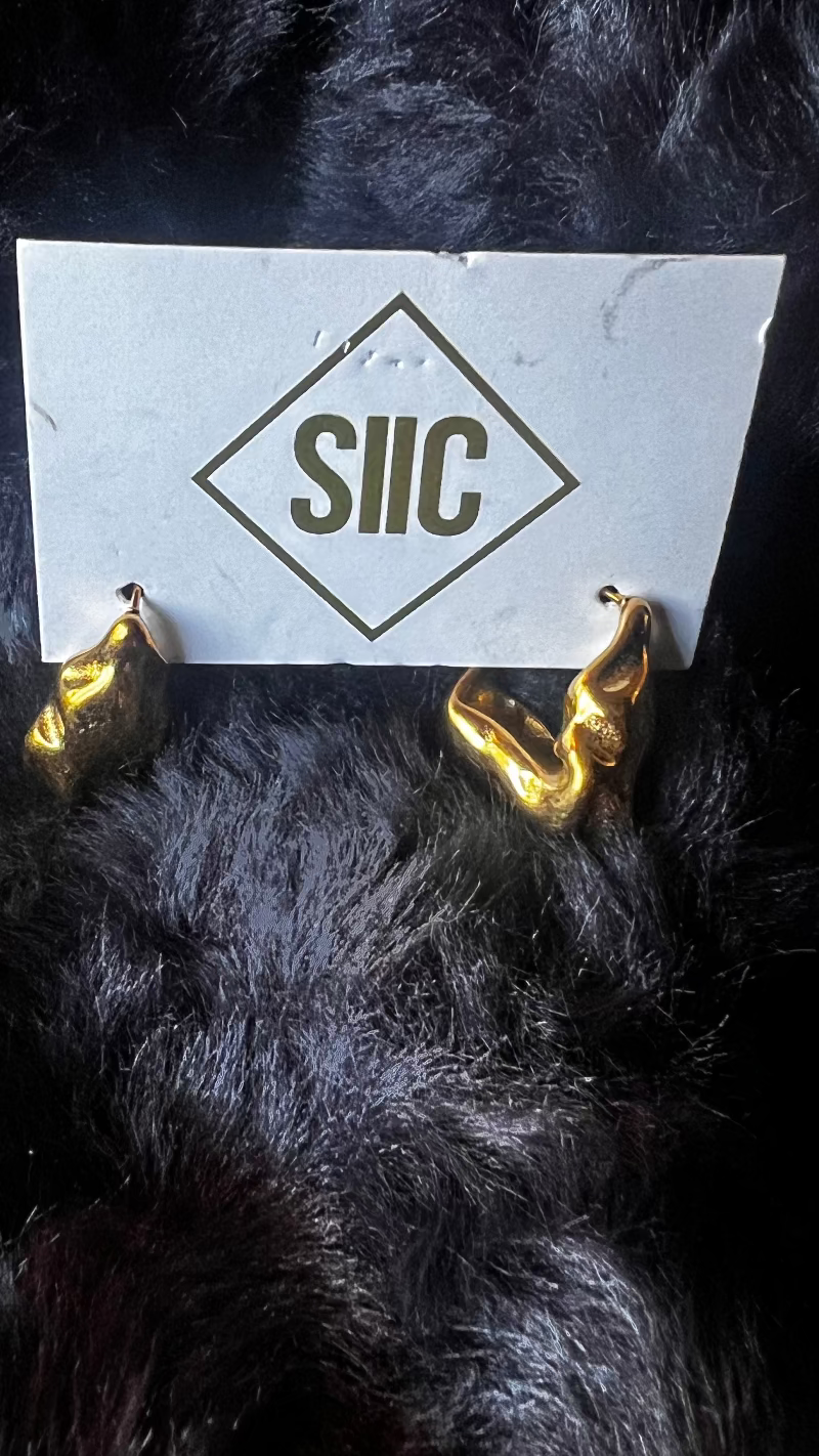 Gold devil horns with a white card displaying 'SIIC' on a dark background