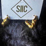 Gold devil horns with a white card displaying 'SIIC' on a dark background