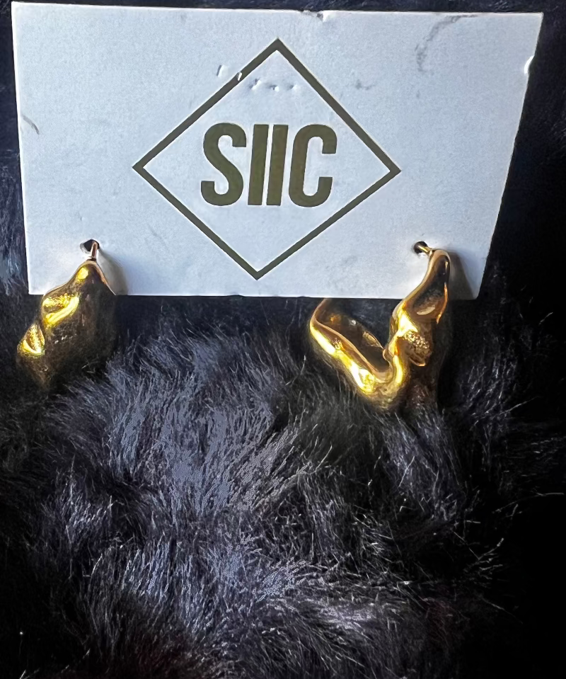 Gold devil horns with a white card displaying 'SIIC' on a dark background