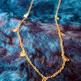 Gold necklace with small beads on a blue fur background