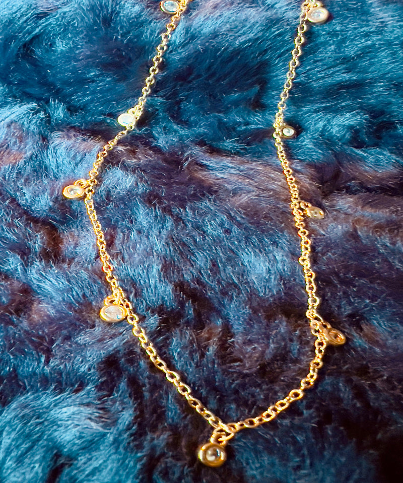 Gold necklace with small beads on a blue fur background