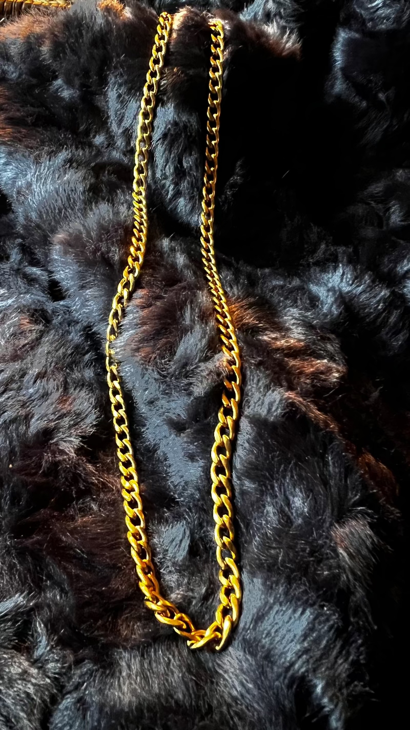 Gold chain necklace on a black fur background