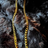 Gold chain necklace on a black fur background