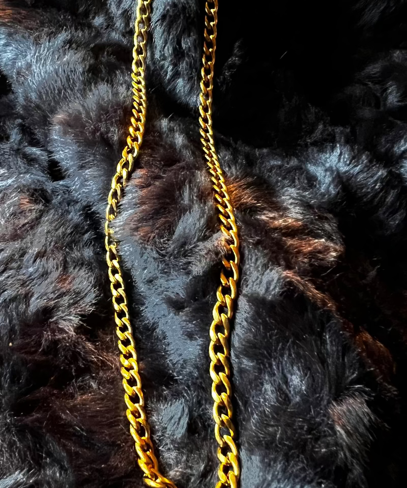 Gold chain necklace on a black fur background