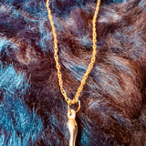 Gold necklace with a pendant on a fur background
