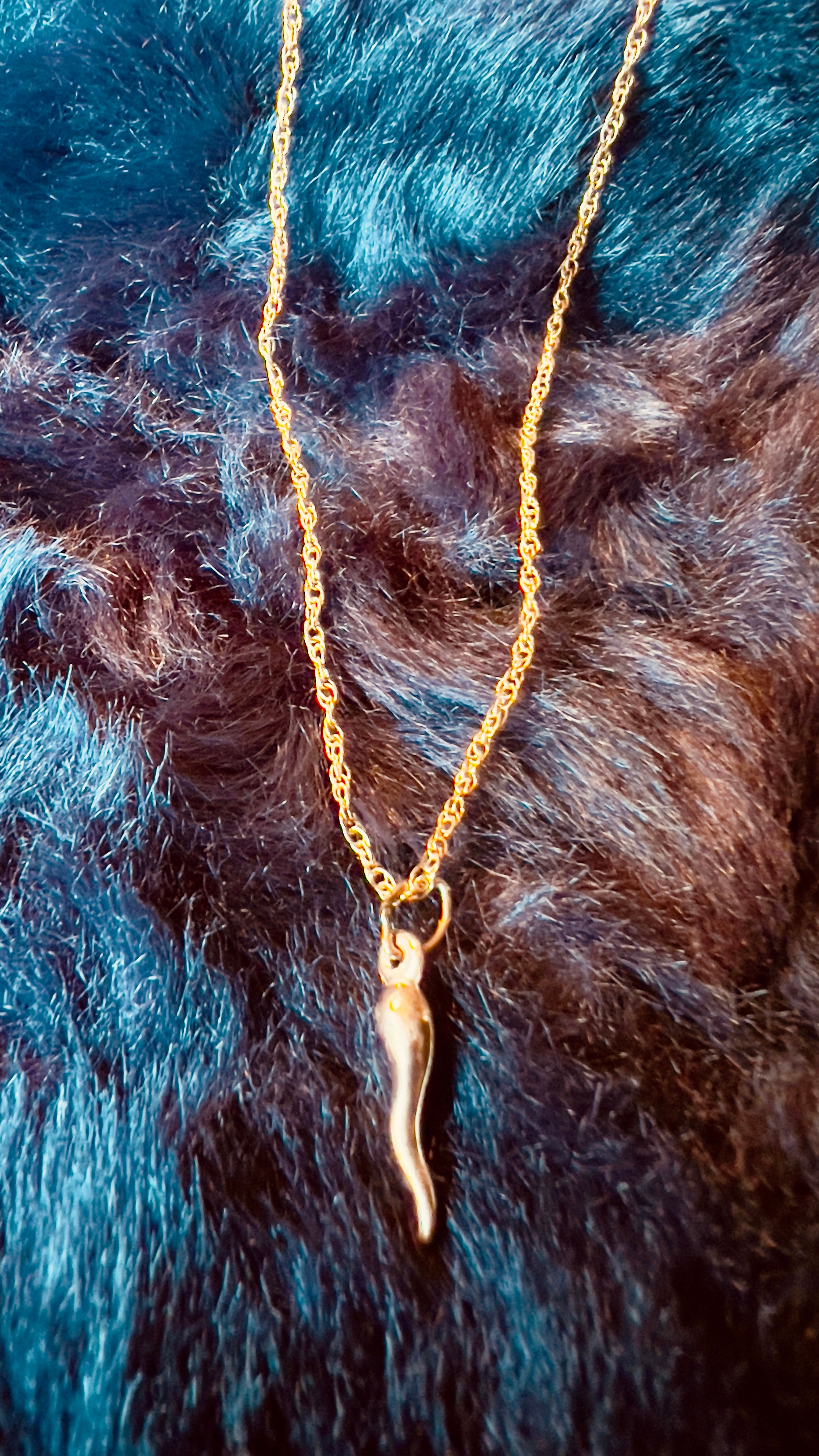 Gold necklace with a pendant on a fur background