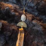 necklace with a gold and beige pendant on a dark fur background