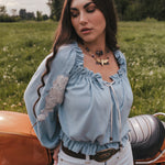 Woman standing next to a motorcycle in a field wearing Soul Sister since 1969