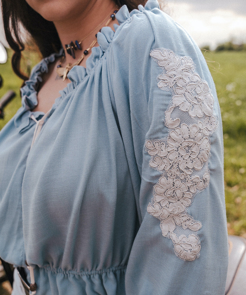 Light blue peasant blouse with lace sleeves worn by a person in an outdoor setting clothing by Soul Sister since 1969