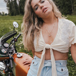 Woman standing next to a motorcycle in a grassy field Soul wearing Sister since 1969.