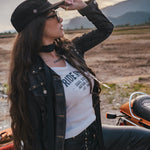 Woman with long hair and a hat standing outdoors with mountains in the background wearing Soul Sister since 1969
