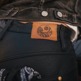 Close-up of a dark jacket with a leather patch featuring a logo  Soul Sister since 1969.