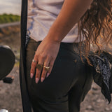 Person wearing black pants with a focus on their hand and jewelry wearing clothing designed and made by Soul Sister since 1969.