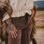 Person wearing a fur coat and brown pants with a scenic background wearing Soul Sister since 1969