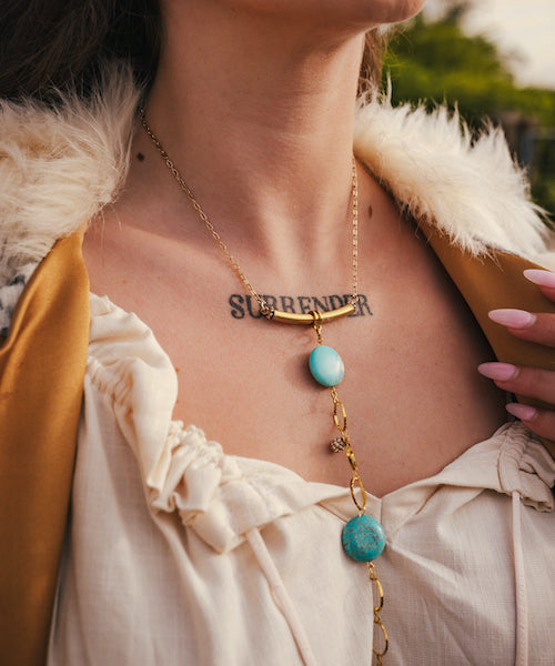 Necklace with turquoise stones and gold chain worn by a person outdoors wearing soul sister since 1969