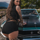 Woman with tattoos leaning on a vintage car in an outdoor setting wearing Soul Sister since 1969